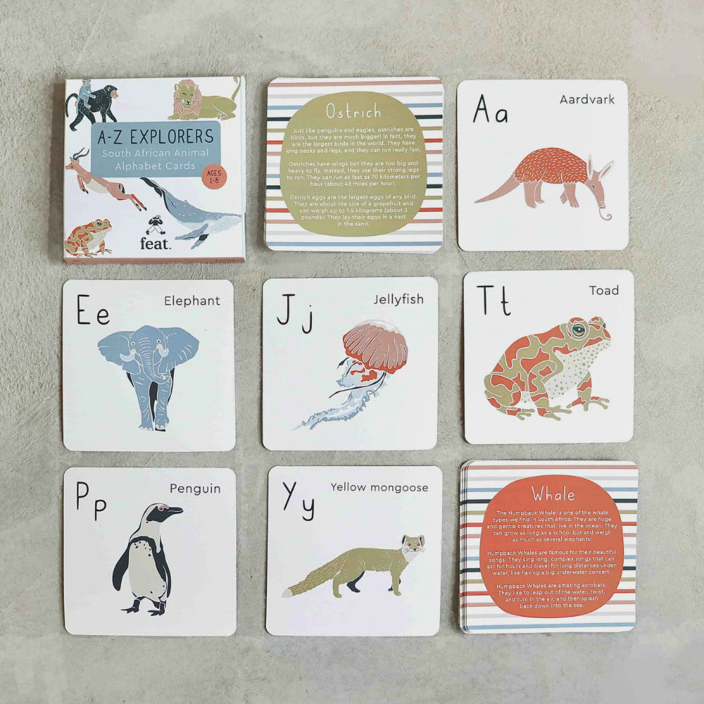 Set of educational alphabet cards with animal illustrations on a gray surface