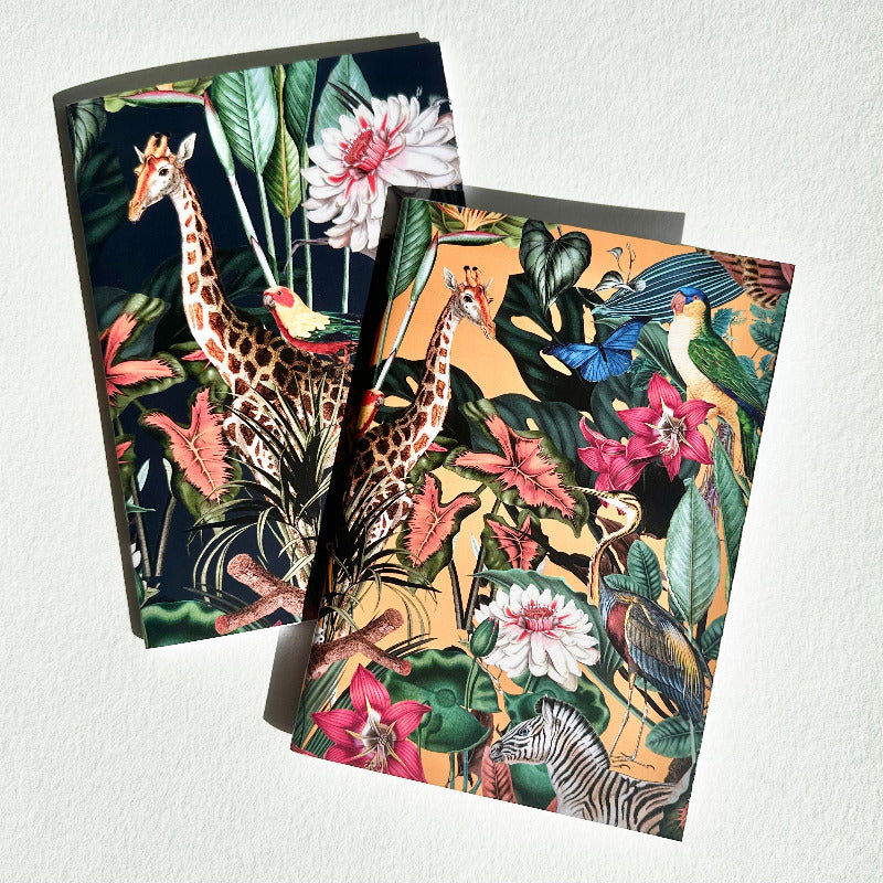 Two notebooks with tropical animal and plant designs on a white background