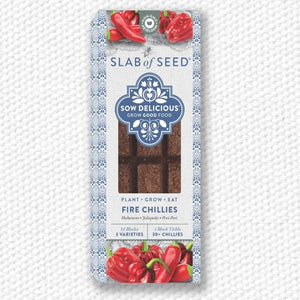 Packaged slab of seed with fire chillies on a textured white background