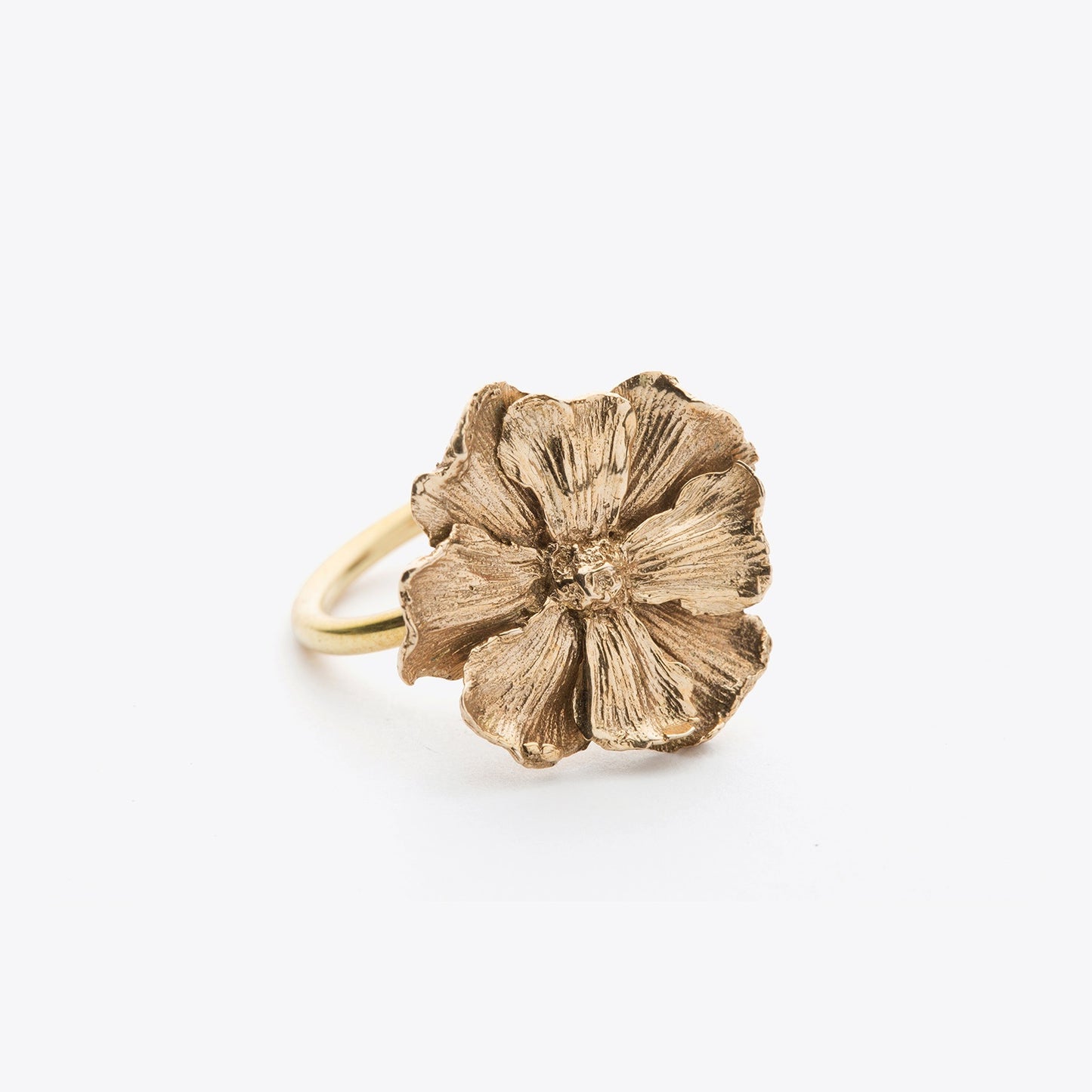 Bronze ring with a textured flower design on a white background