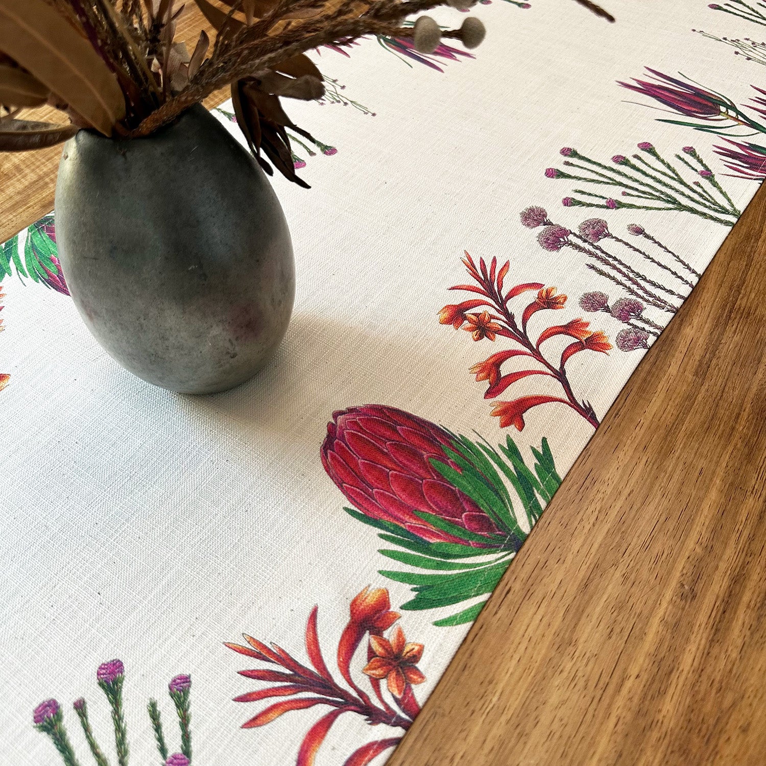 Fybos floral patterned tablecloth with a vase and dried flowers on a wooden surface