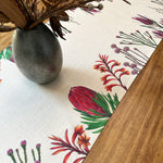 Load image into Gallery viewer, Fybos floral patterned tablecloth with a vase and dried flowers on a wooden surface
