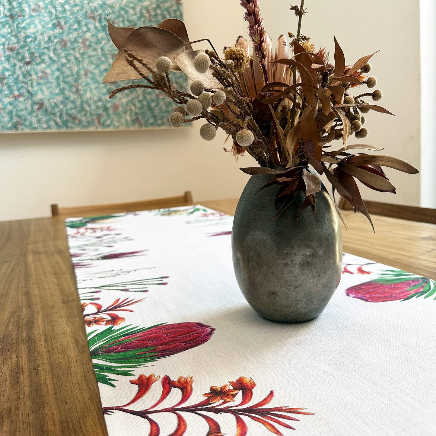 Decorative vase with dried flowers on a table with a fynbos floral table runner