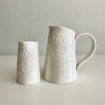 Load image into Gallery viewer, Two white ceramic jugs with embossed floral patterns on a light gray background
