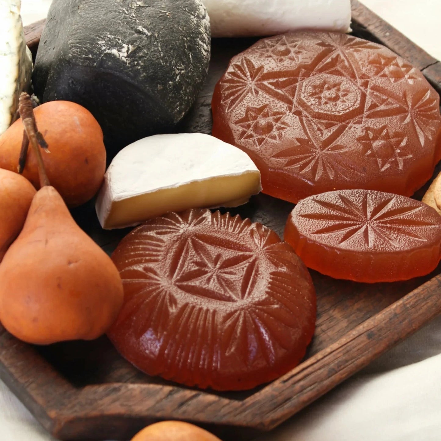 Jelly with geometric patterns on a wooden tray with cheeses.