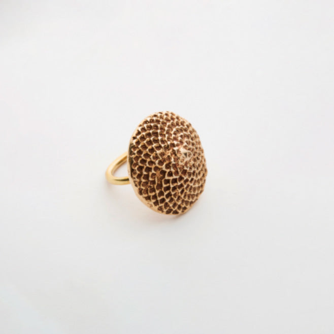 Bronze ring with textured design on a white background