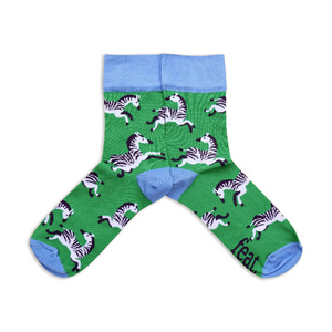 A pair of socks with a green background featuring zebra illustrations.