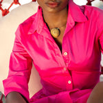 Load image into Gallery viewer, Person wearing a bright pink shirt with a bronze necklace.
