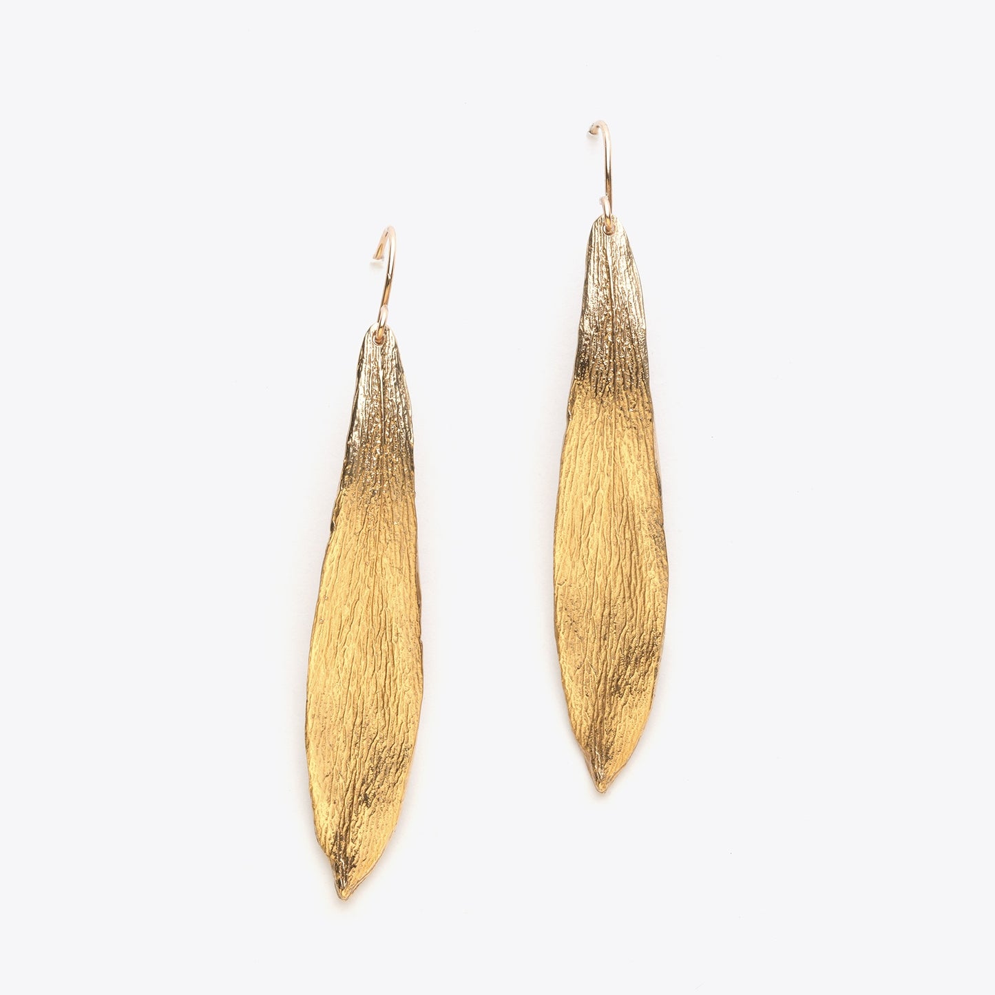 Pair of bronze leaf-shaped earrings on a white background