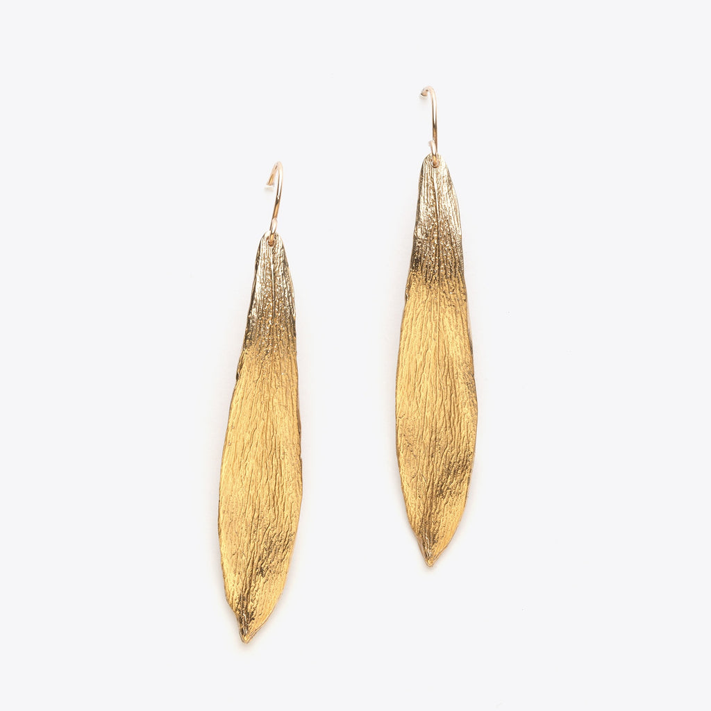 Pair of bronze leaf-shaped earrings on a white background