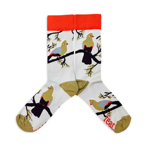 A pair of light blue cotton socks with a pattern of bright green and blue knysna loerie birds and the word 'feat' on the sole.