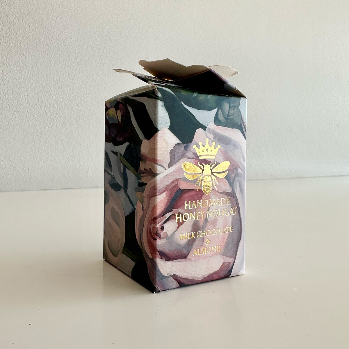 Handmade honey nougat packaging with floral design and bee logo on a white background