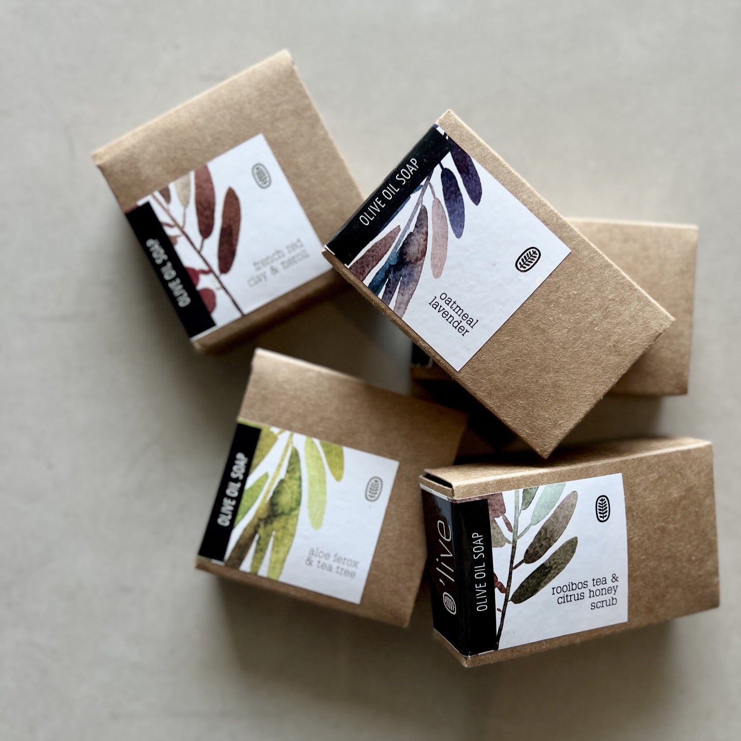 Five brown soap boxes with labels on a light gray background