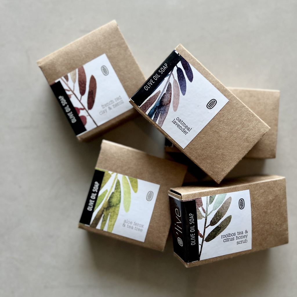 Five brown soap boxes with labels on a light gray background