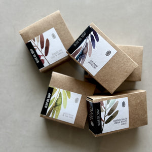 Five brown soap boxes with labels on a light gray background