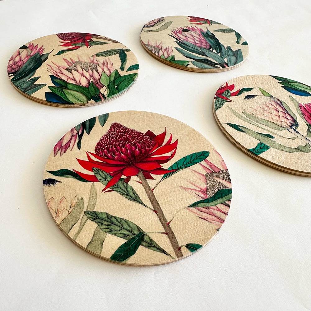Set of four round coasters with floral designs on a white background