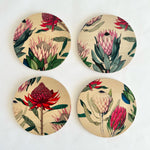 Load image into Gallery viewer, Four circular coasters with floral designs on a beige background
