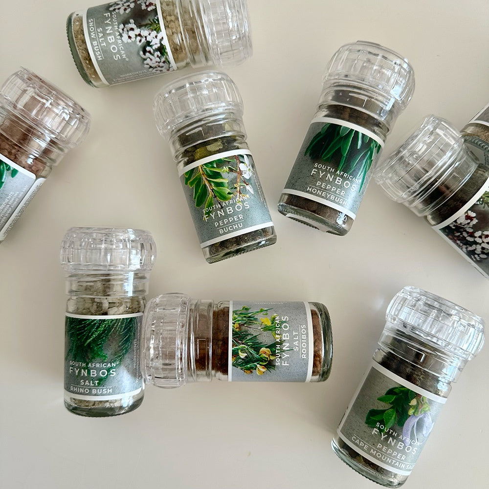 Collection of salt & pepper grinders with labels on a light background