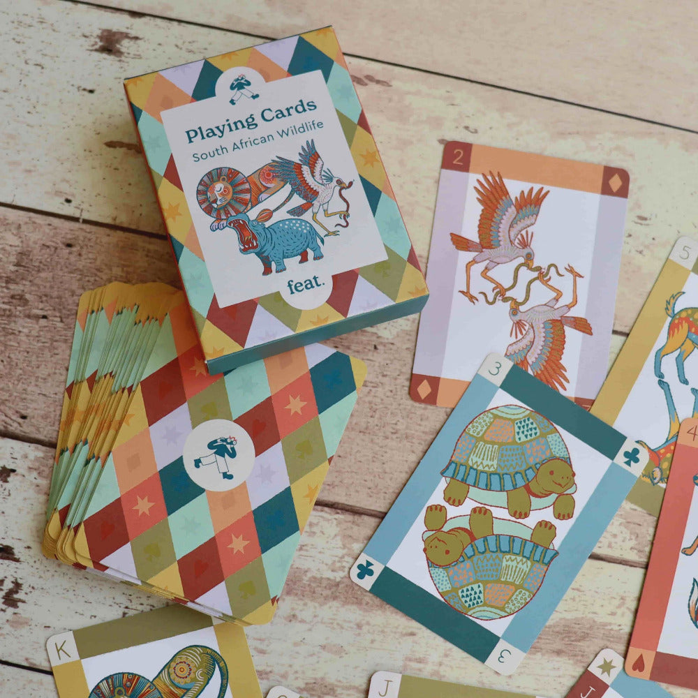 Colorful playing cards with South African wildlife design on a wooden surface