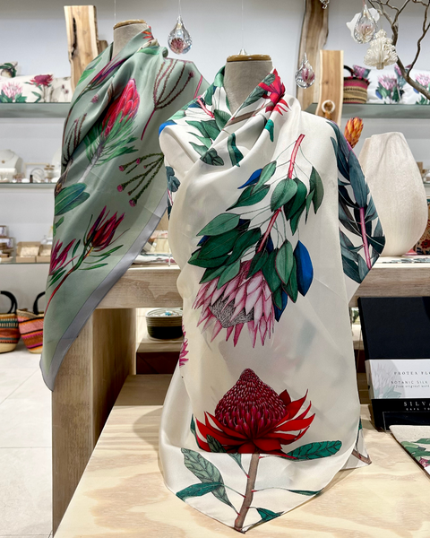 Protea and fynbos Floral-patterned scarves on mannequins in a store setting.