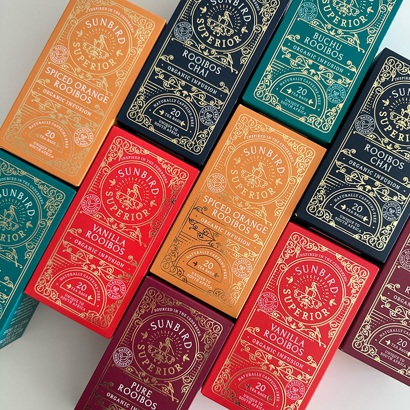 Sunbird Superior rooibos tea packages in various colors on a white background