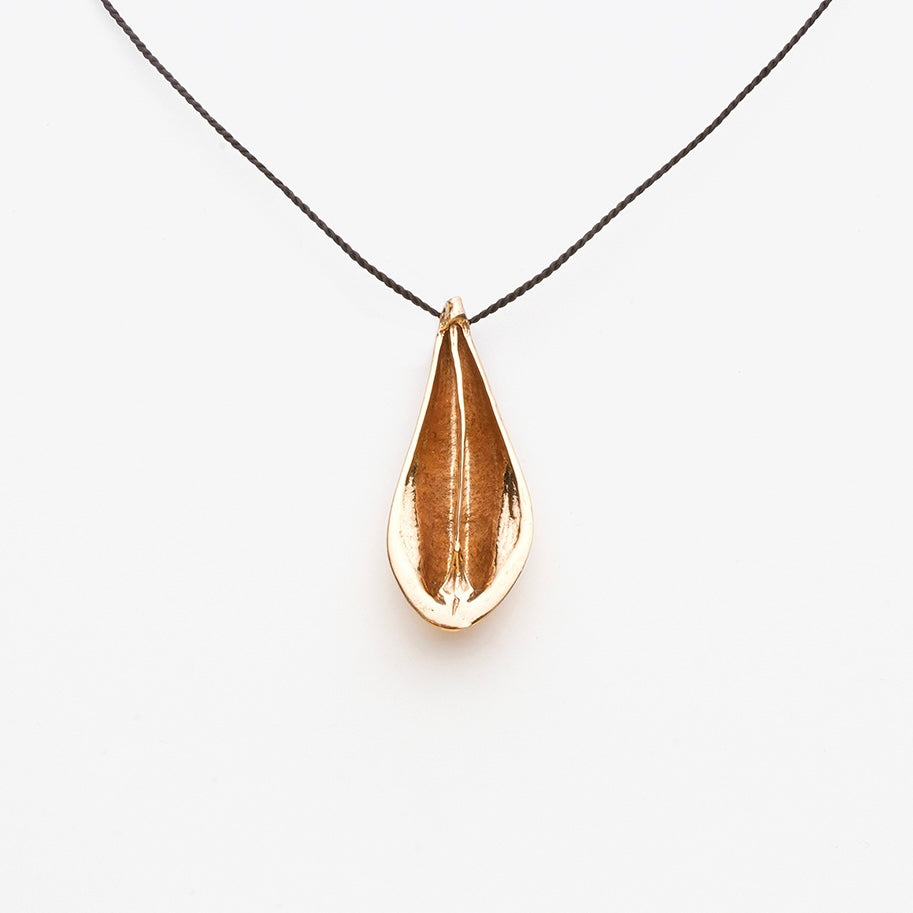 Bronze teardrop shaped pendant on a black cord against a white background