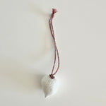Load image into Gallery viewer, White ceramic decoration on a string against a light background
