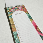 Load image into Gallery viewer, Floral-patterned planner with a January calendar on a light gray background
