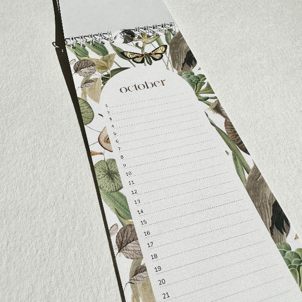 Floral-patterned planner with a calendar for October on a light gray background