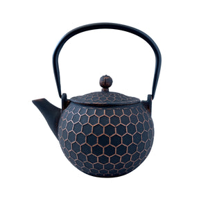 Black cast iron teapot with hexagonal pattern on a white background