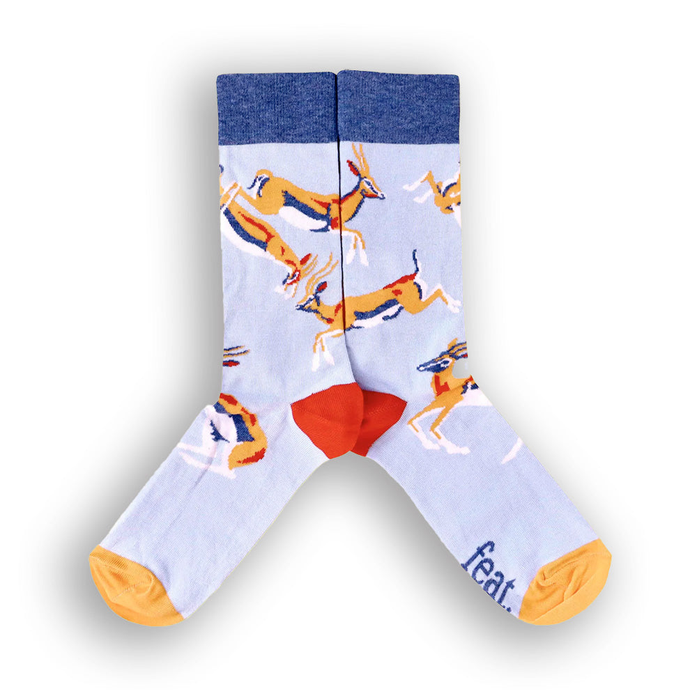 A pair of socks with a light blue background featuring springbok illustrations.