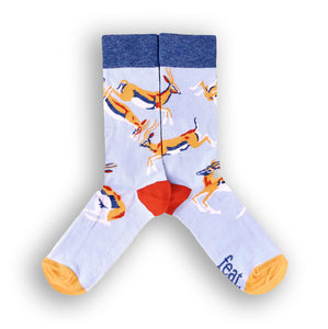 A pair of socks with a light blue background featuring springbok illustrations.