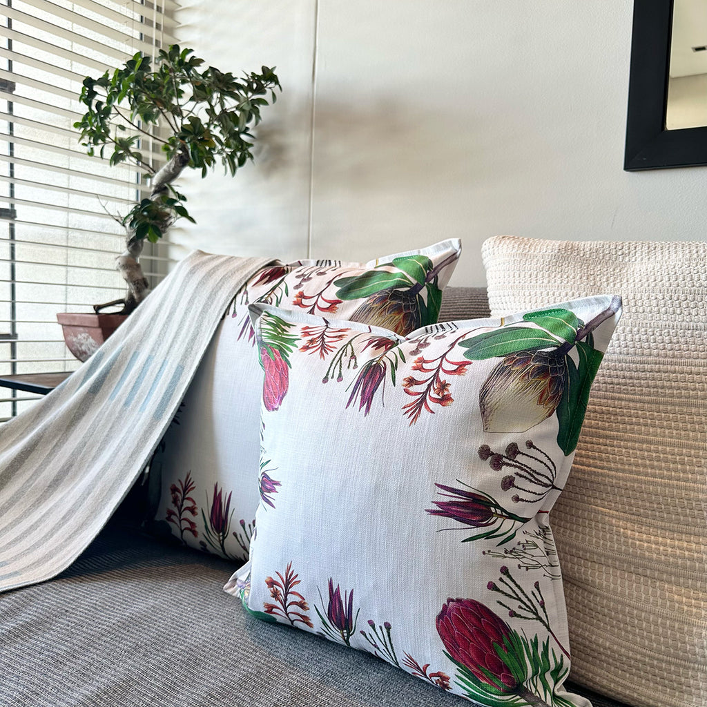 Fybos floral-patterned pillow on a couch with a bonsai in the background