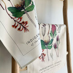 Load image into Gallery viewer, Two tea towels with botanical fynbos designs hanging on a wooden rack.
