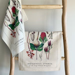 Load image into Gallery viewer, Two towels with fynbos floral designs hanging on a wooden ladder against a light gray wall.
