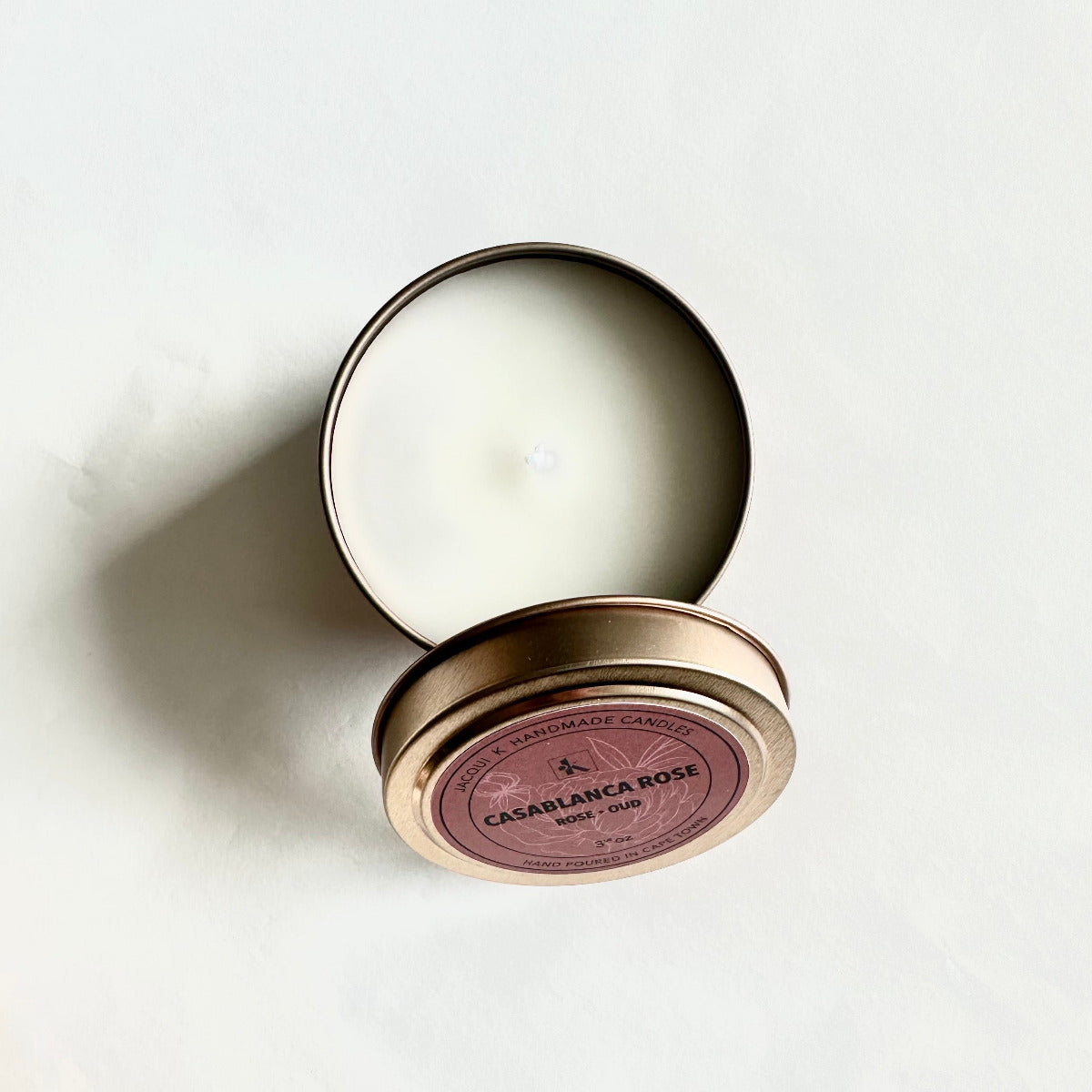 Candle in a tin with 'Casablanca Rose' label on a white background
