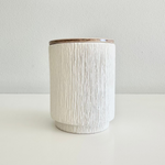 Load image into Gallery viewer, White textured candle jar with wooden lid on a light gray background
