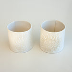 Load image into Gallery viewer, A pair of handcrafted ceramic espresso cups each imprinted with either a king protea or pincushion silhouette on a white background.
