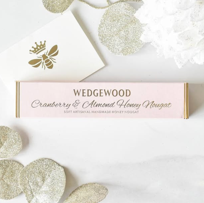 Wedgewood Cranberry & Almond Honey Nougat packaging with decorative elements on a light background
