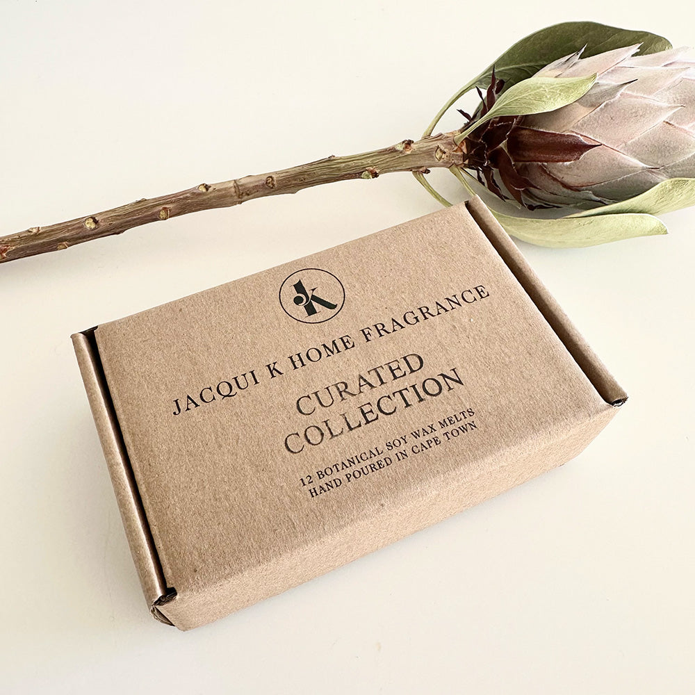 Jacqui K Home Fragrance Curated Collection box with a flower on a light background