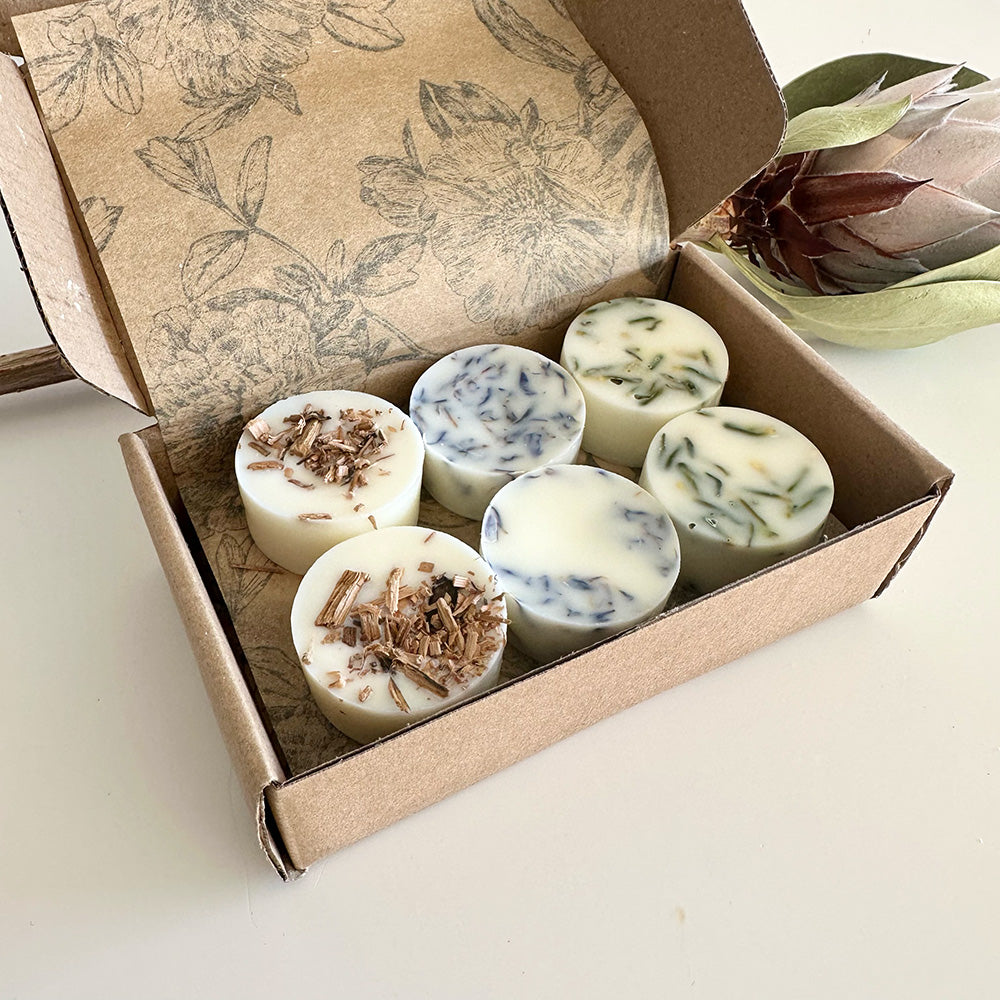 Box of round wax melts with natural ingredients on a light background