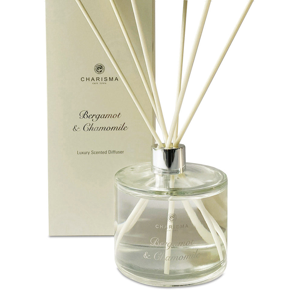A clear glass diffuser bottle with bergamot and chamomile fragrance, featuring a label with the brand name Charisma Candles and the product name Bergamot & Chamomile - Luxury Scented Diffuser.