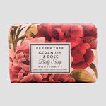 Load image into Gallery viewer, Bar of soap with floral design and &#39;Peppertree Geranium &amp; Rose&#39; label on a light gray background
