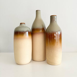 Three ceramic bottles with gradient coloring on a white background