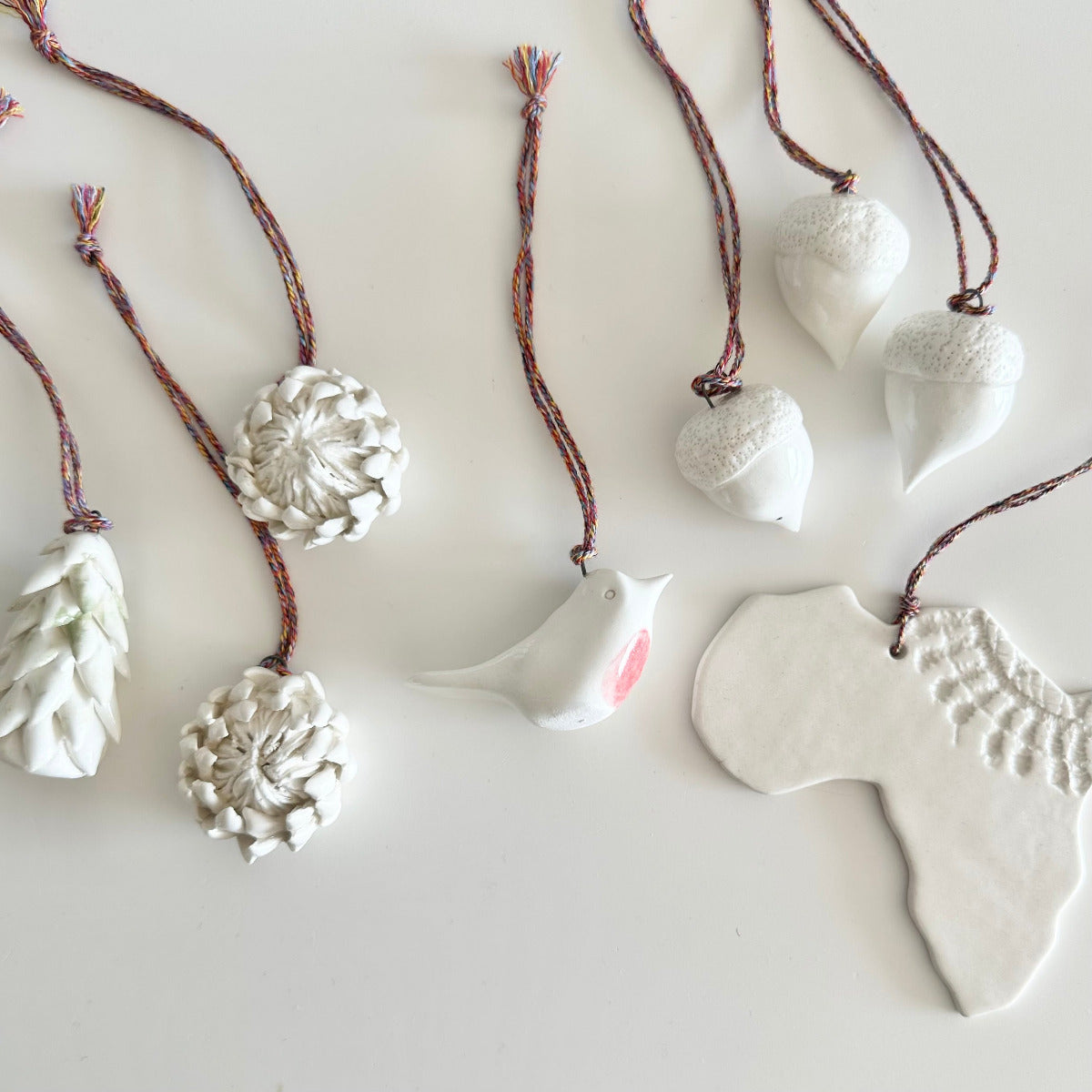 White ceramic ornaments on strings against a light background