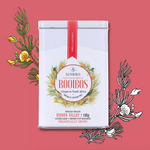 Sunbird Rooibos tea tin on a pink background with botanical illustrations.