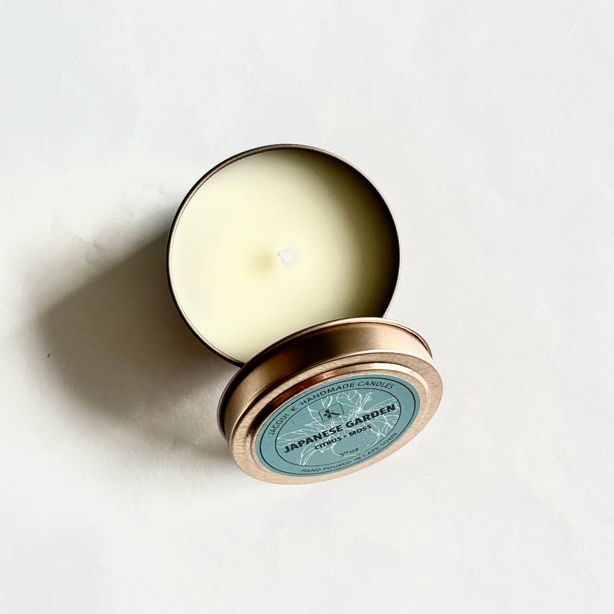 Candle in a tin with 'Japanese Garden' label on a white background