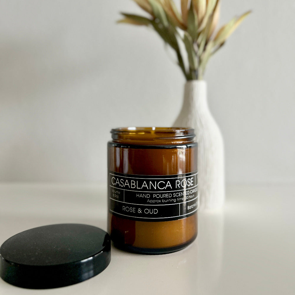 Candle jar labeled 'Casablanca Rose' with a black lid on a neutral background
