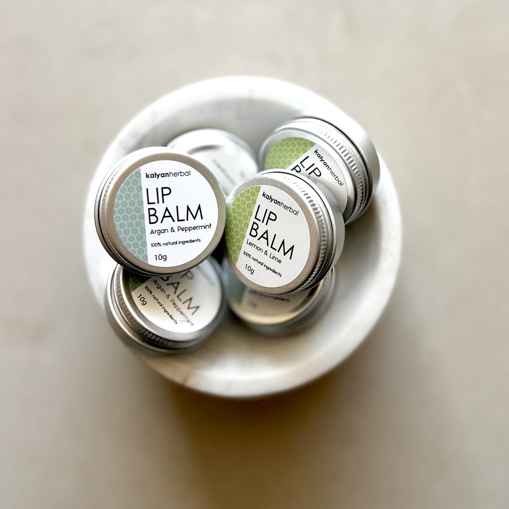 Lip balm containers in a white dish on a beige background