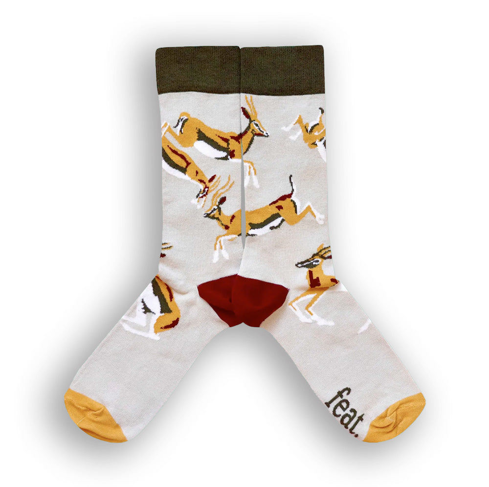 A pair of socks with a khaki background featuring springbok illustrations.